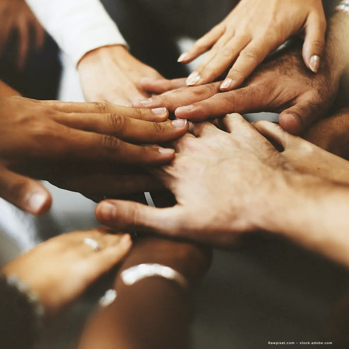 Hände von im Kreis stehenden Menschen verschiedener Nationen berühren sich in der Mitte. Kooperationspartner des Ärztenetz BOHRIS.