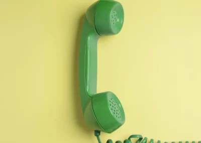 Ein grünes Telefon vor einem gelben Hintergrund.