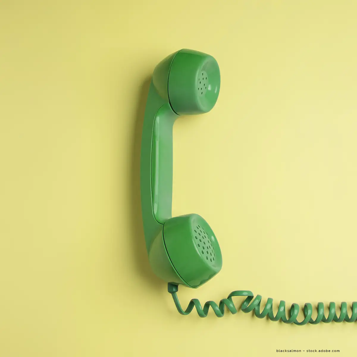 Ein grünes Telefon vor einem gelben Hintergrund.