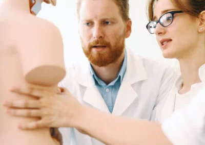 Zwei angehende Mediziner schauen sich die Anatomie an einer Puppe an.